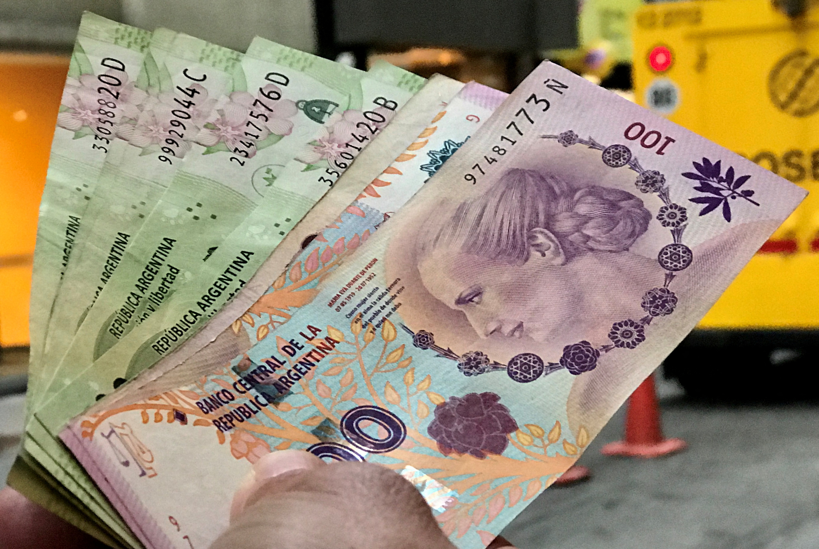 Hand holding Argentine Pesos